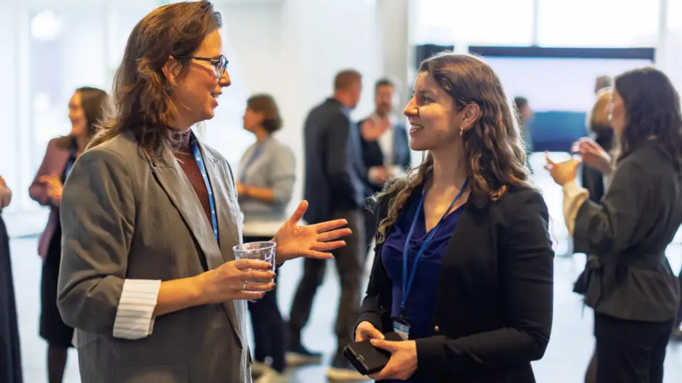 Two women networking and drinking coffee
