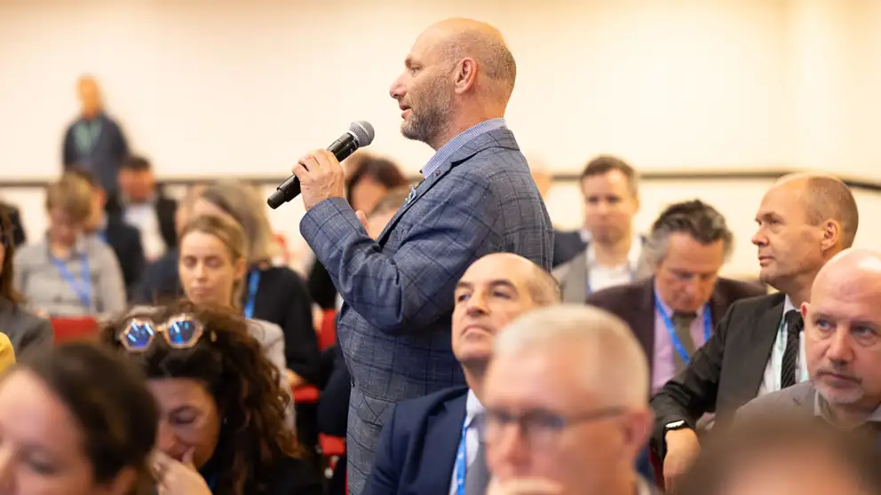 Man with microphone asking a question.