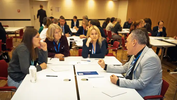 Four people having discussions around a table.