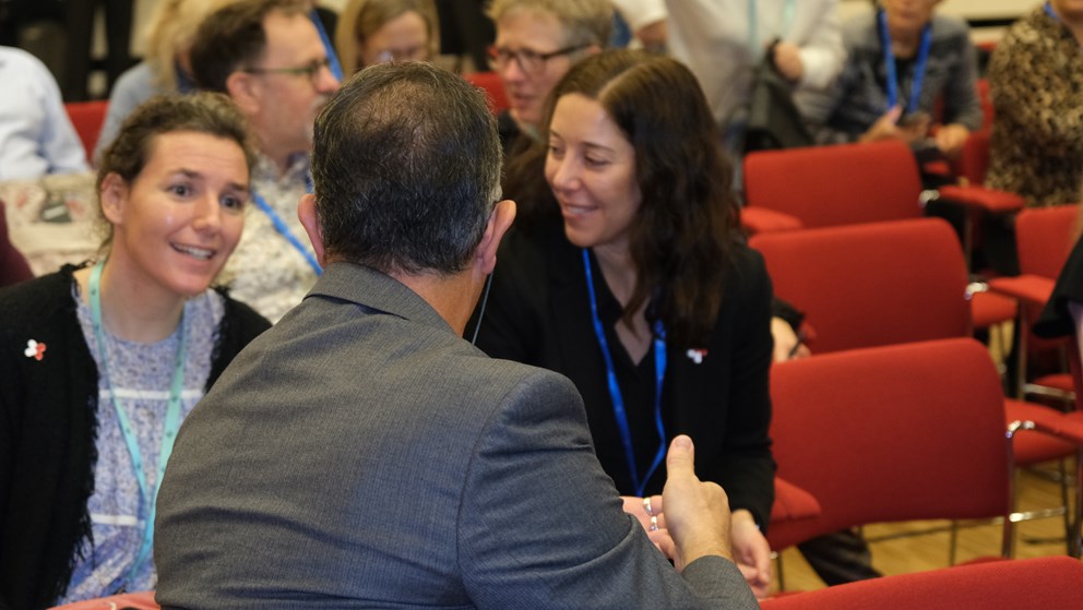 Three people sitting down and talking