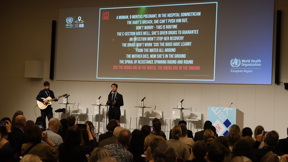 Band with two people are singing on stage. Power point with lyrics in the back