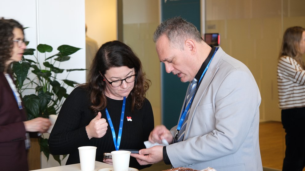 Woman and man netowrking. Man showing something on his phone