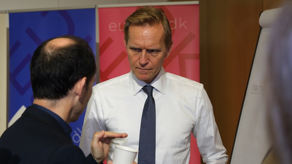 Two men discussing something in fron of whiteboard