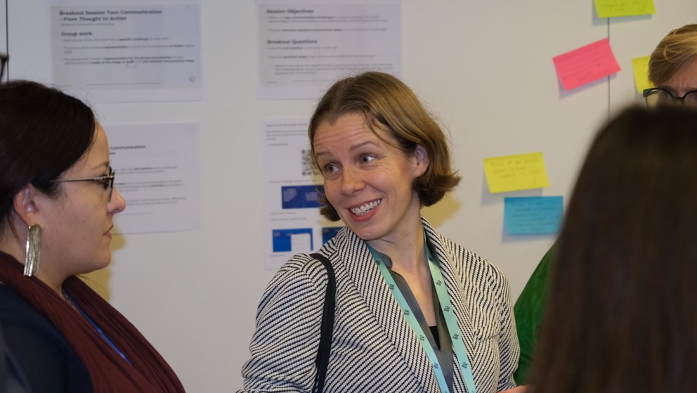 Two women talking in front of whiteboard